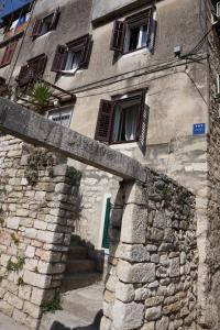 a stone building with a stone wall in front of it at Mućo Varoš in Split