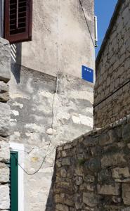 a cord hanging from the side of a stone building at Mućo Varoš in Split