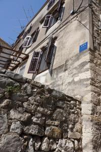 an old stone building with windows and a stone wall at Mućo Varoš in Split