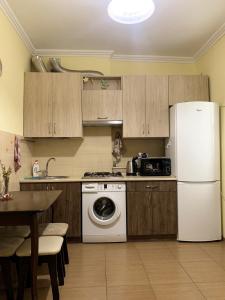 a kitchen with a white refrigerator and a dishwasher at Homey apartment on Vicheva Str. in Lviv