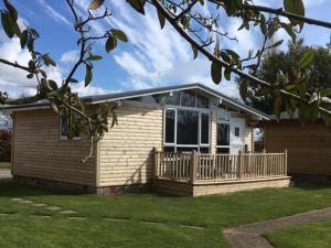 a small house with a porch and a deck at Chalet 12a in Seaton