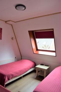 two beds in a small room with a window at Hotel Cafe 't Zonneke in Oosterhout