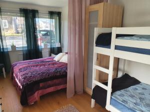 a bedroom with two bunk beds and a window at Skärgårdsidyll på Björkö med gångavstånd till havet in Skarvik