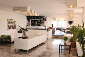 una sala de estar con muebles blancos y plantas. en Hotel Diplomatic, en Riccione