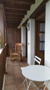 a room with a table and a chair on a porch at Camin de Muniellos apartamentos rurales in Cangas del Narcea