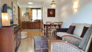 a living room with a couch and a dining room at Camin de Muniellos apartamentos rurales in Cangas del Narcea