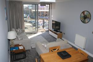 a living room with a couch and a table and a tv at Brittany Street, Plymouth in Plymouth