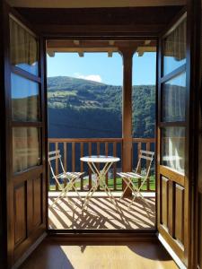 a view from the porch of a house with a table and chairs at Camin de Muniellos apartamentos rurales in Cangas del Narcea
