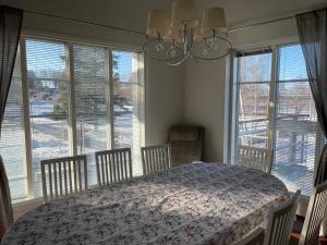 a dining room with a table and chairs and windows at Rauhan Marinella Apartments in Imatra
