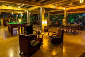 a room with a pool table and some chairs at La Palmeraie D'angkor in Siem Reap