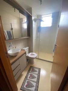 y baño con aseo, lavabo y ducha. en Apartamento em Penha SC, en Penha