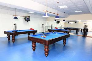 three billiard tables in a room with blue floors at Hotel Caldas Internacional in Caldas da Rainha