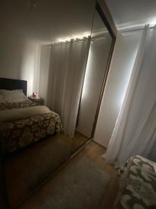 1 dormitorio con cama y espejo en Apartamento em Penha SC, en Penha