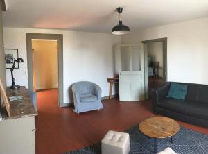 ein Wohnzimmer mit einem Sofa und einem Tisch in der Unterkunft Les Gites Saint Aignan - Proche du Zoo de Beauval in Saint-Aignan