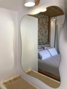 - un miroir dans une chambre avec un lit dans l'établissement La Grande Vue private villas, à Vívlos