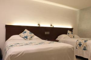 Voodi või voodid majutusasutuse Hotel Puerta Chichen toas