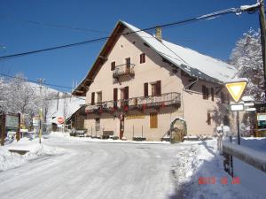 a building on the side of a snow covered street at appartement edlweiss 4 pers dans gite"la maison d'augustin" classé 3 étoiles, la tour,73530 st jean d'arves in Saint-Jean-dʼArves