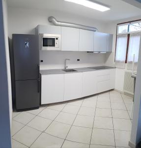 eine Küche mit weißen Schränken und einem Kühlschrank in der Unterkunft Casa Le Vignole - Aosta in Aosta