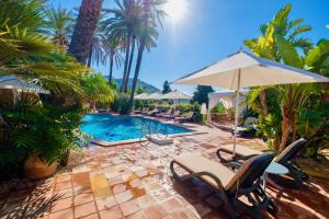 - une piscine avec des chaises et un parasol dans l'établissement Agriturismo Vecchia Masseria Charme&Relax, à San Michele di Ganzaria