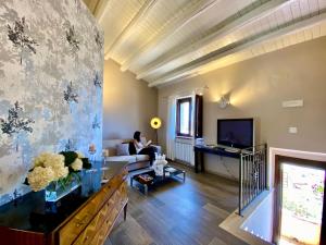 a woman sitting on a couch in a living room at Agriturismo Vecchia Masseria Charme&Relax in San Michele di Ganzaria
