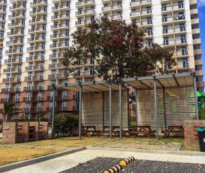 un grande condominio con un rifugio per picnic di fronte ad esso di Saekyung Condominium a Mactan