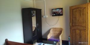 a room with a mirror and a chair and a television at Poomong Homestay in Darjeeling