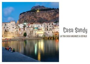 a group of people sitting on the shore of a body of water at Casa Sandy in Cefalù