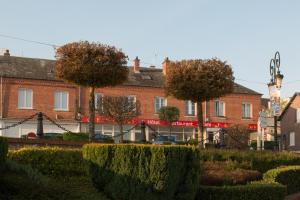 a building with trees and bushes in front of it at Entre Nous in Rozoy-sur-Serre