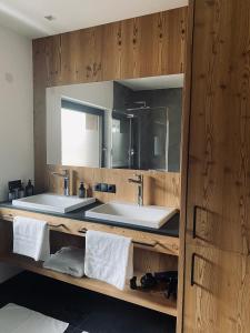 a bathroom with two sinks and a mirror at Florisa Mountain Penthouse in San Vigilio Di Marebbe