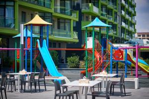 a playground with tables and chairs in front of a building at Sea Shore apartments - Spa n Pools beach resort in Mamaia