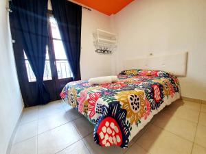 - une chambre avec un lit et une couverture colorée dans l'établissement Arc House Ribera Only Adults, à Cordoue