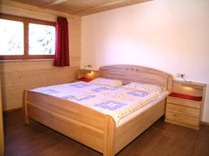 a bedroom with a wooden bed and a window at Residencesora in San Vigilio Di Marebbe