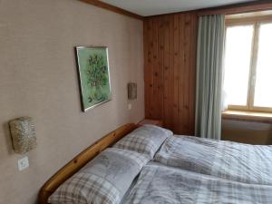 a bed in a bedroom with a picture on the wall at Hotel Alpenrose in Maienfeld