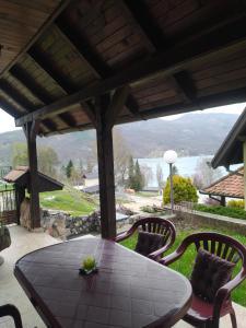 una mesa y sillas en un patio con vistas en Vila Jezero en Bajina Bašta