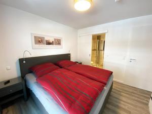 a large bed with a red comforter in a bedroom at Ferienresidenz Cuxhaven in Cuxhaven