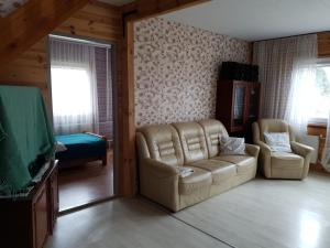 a living room with a couch and two chairs at Kāpas in Jūrkalne
