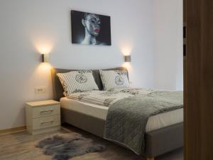 a bedroom with a bed and a painting on the wall at Armony Apartament Timisoara in Timişoara