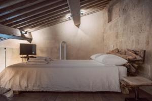 a bedroom with a bed and a tv in a room at Piazza San Donato Casa Vacanze in Bagnoregio