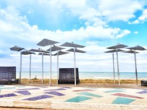 a group of umbrellas and chairs on a beach at Appartamento Mare Nardo in Porto SantʼElpidio