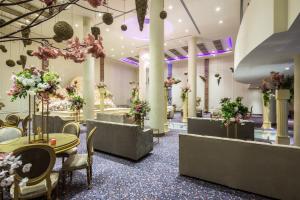 a lobby with tables and chairs and flowers at Mena Hotel Tabuk in Tabuk