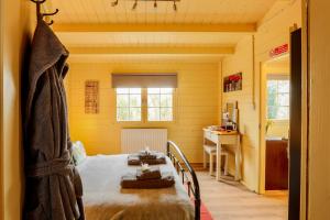 a bedroom with a bed in a yellow room at Sunset log cabin in Sudbury