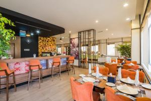 um restaurante com mesas e cadeiras e um bar em Mena Hotel Tabuk em Tabuk