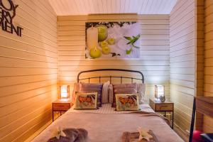 een slaapkamer met een bed in een kamer met houten wanden bij The Retreat Log Cabin in Sudbury