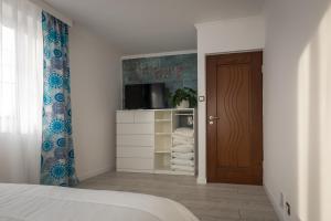 een slaapkamer met een bed en een televisie en een deur bij ApartsW241 in Jelenia Góra
