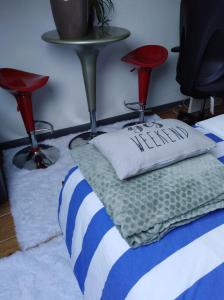 a bed with a pillow and two stools in a room at Un studio à louer ds un endroit calme près de la ville de Dinant in Dinant