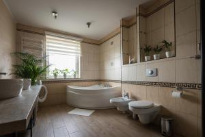 ein Badezimmer mit einer Badewanne, einem WC und einem Waschbecken in der Unterkunft ApartsW241 in Jelenia Góra
