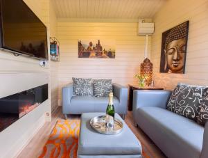 a living room with blue couches and a fireplace at The Retreat Log Cabin in Sudbury