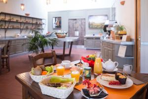 una mesa con alimentos para el desayuno y zumo de naranja en ella en Tenuta Il Cicalino en Massa Marittima