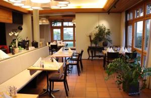 un ristorante con tavoli e sedie in una stanza di Hotel Breiti a Bachenbülach