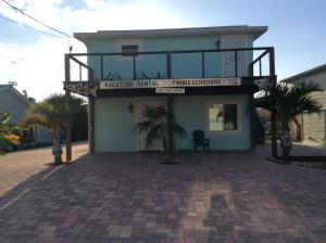 a building with a balcony on top of it at Fort Myers Beach House-on a canal in Fort Myers Beach
